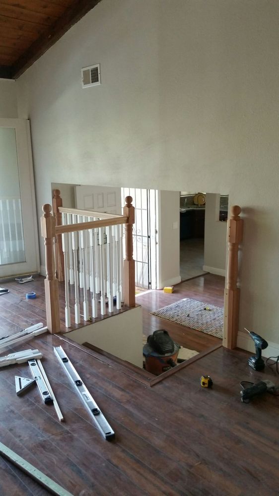 In-progress shot of a home repair professional from Kevin's Handyman building a custom wooden railing around a set of stairs in a San Jose home