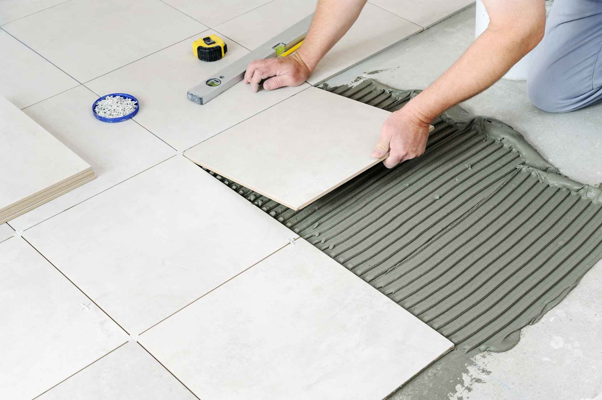 A handyman installs tile floor